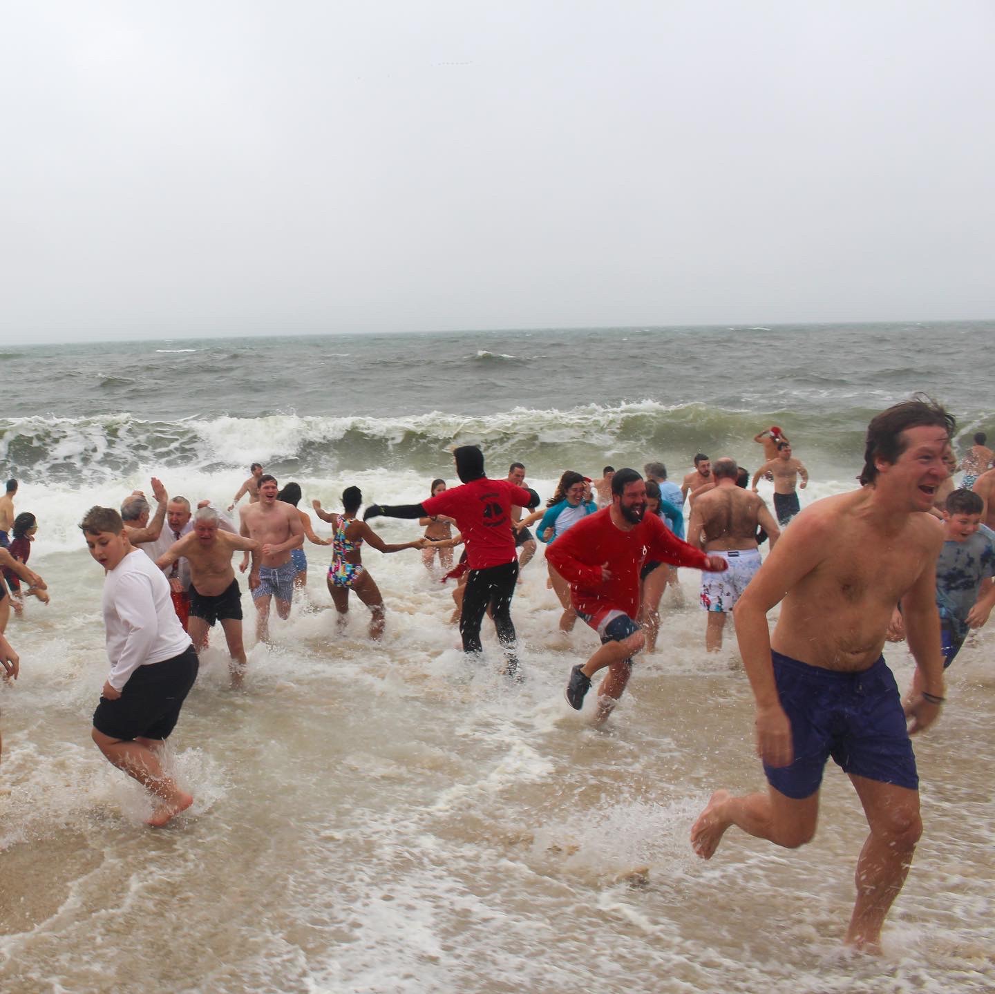 a large group of people running from a wave