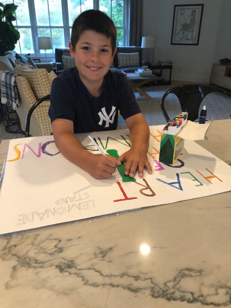 a boy creating a poster using colored pens