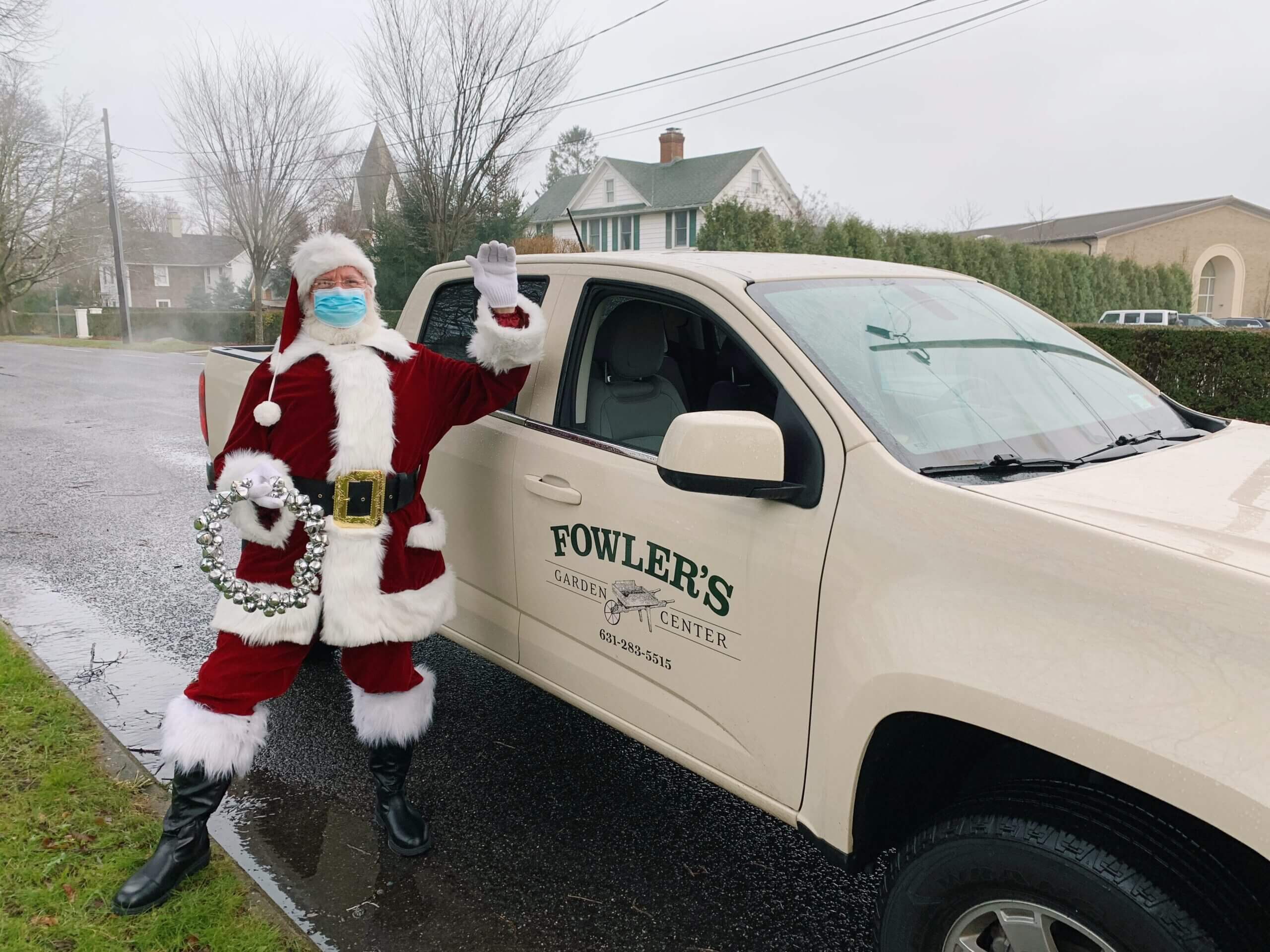A man in Santa Claus costume standing at the car