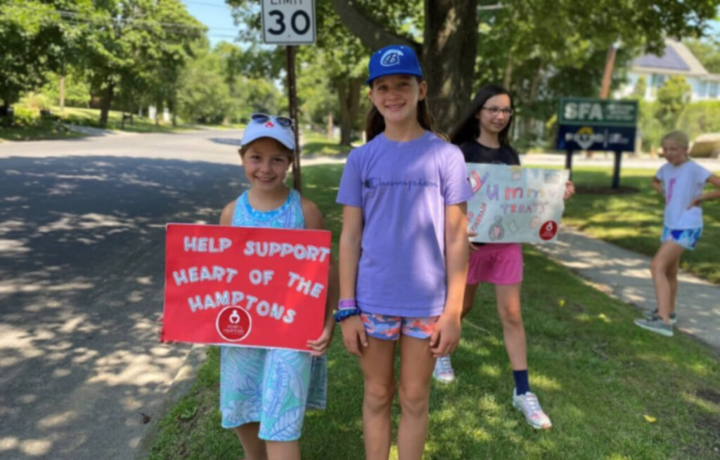Kids holding boards for help support heart of the Hamptons